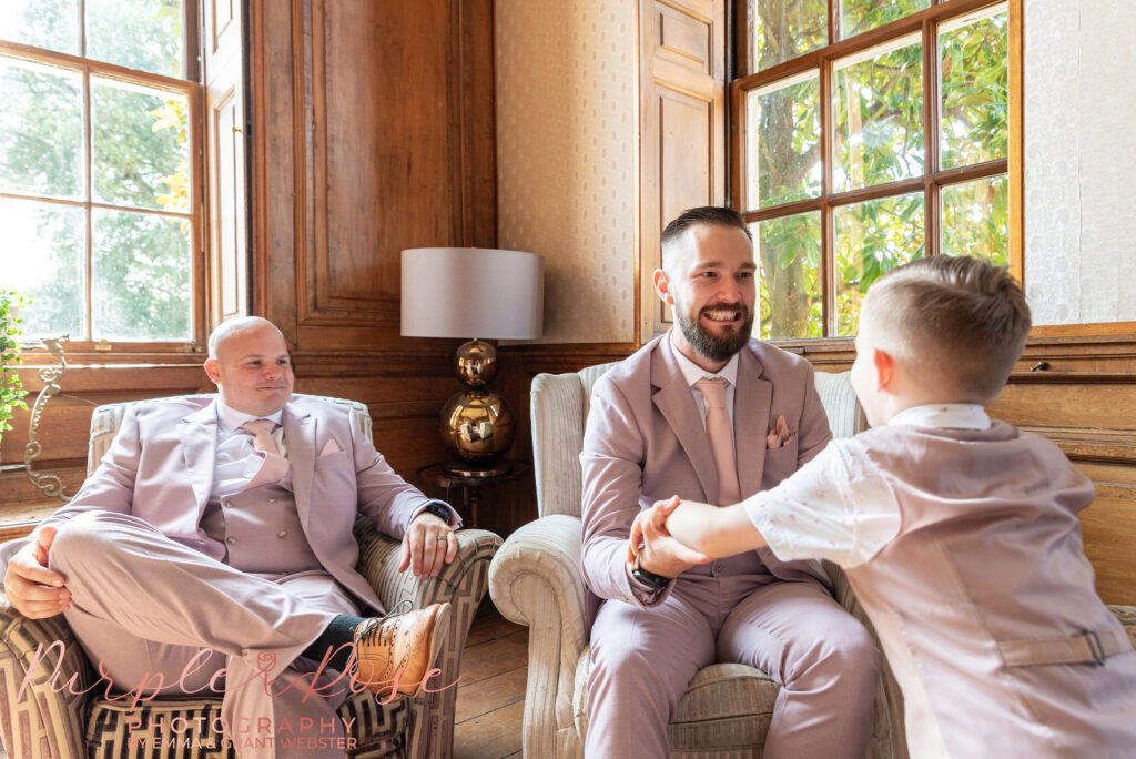 Photo of a groom on his wedding day playing with his son at Chicheley Hall