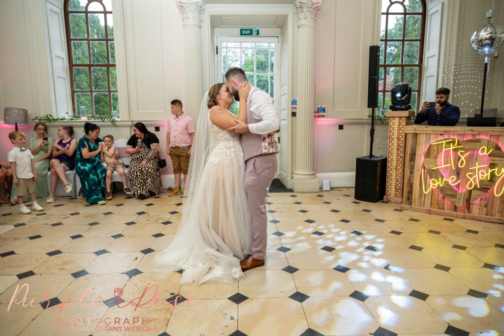 Bride and groom enjoying their first dance as wedding guests look on at Chicheley Hall Milton Keynes