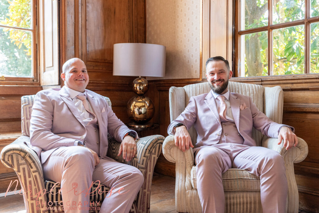 Groom and groomsman sat together on the morning of the wedding day at Chicheley Hall in Milton Keynes
