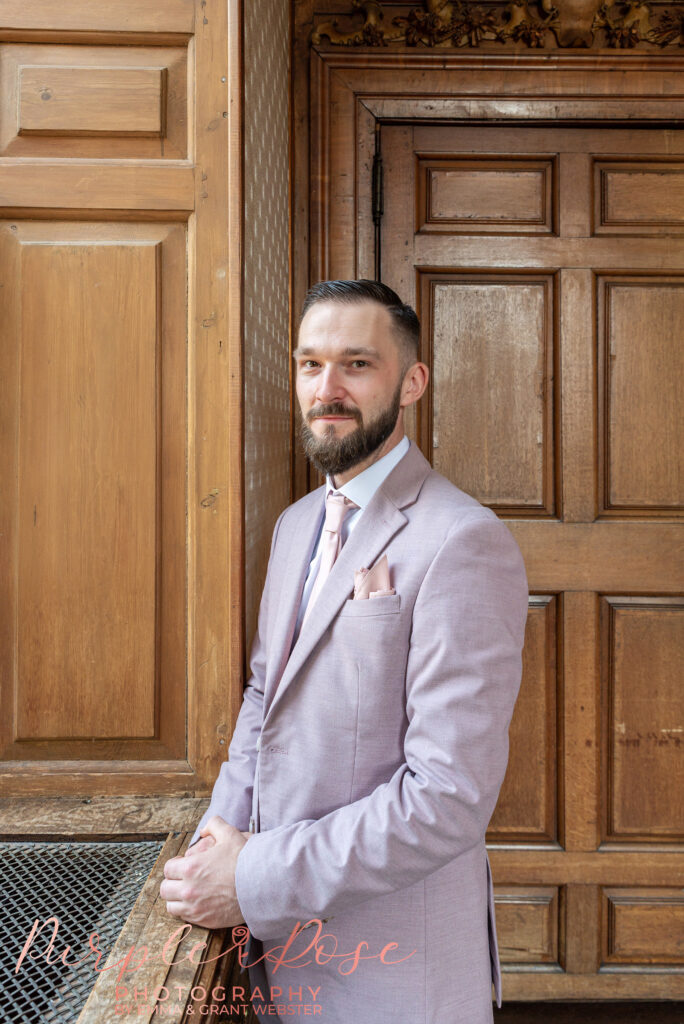 Photo of a groom stood by a window at Chicheley Hall in Milton Keynes