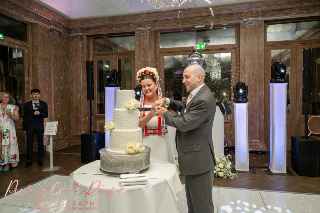 Bride and groom cutting their wedding cake at Fawsley Hall