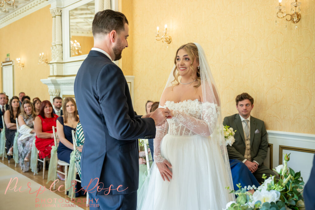 Bride and groom exchanging wedding ring during their wedding in Peterborough 