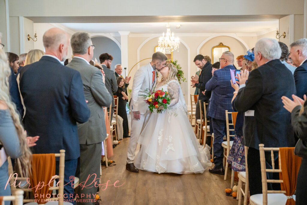 Bride and groom kissing at the end of their wedding ceremony in Bedford