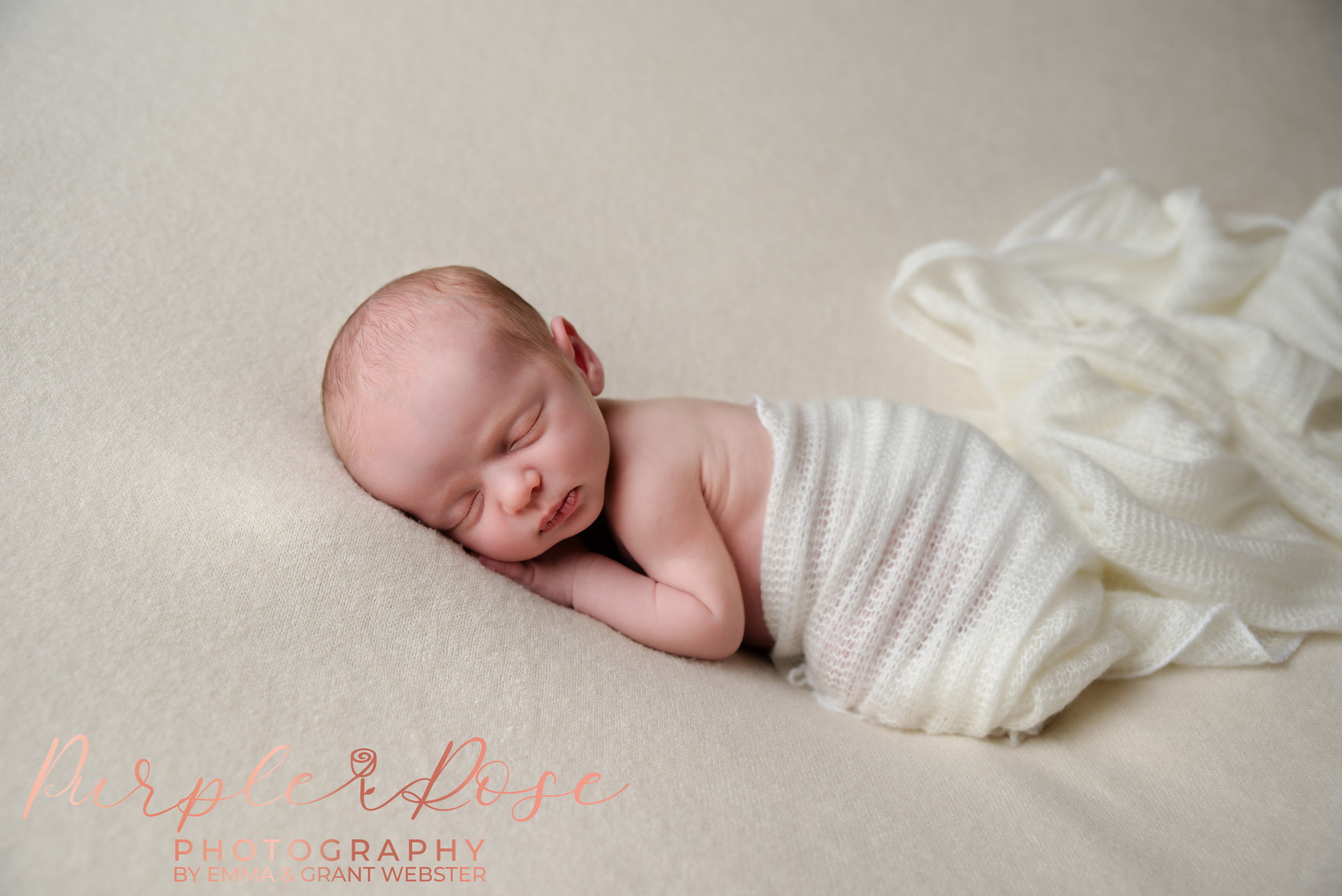 Photo of a newborn baby sleeping on cream blanket at their newborn photo shoot in Milton Keynes