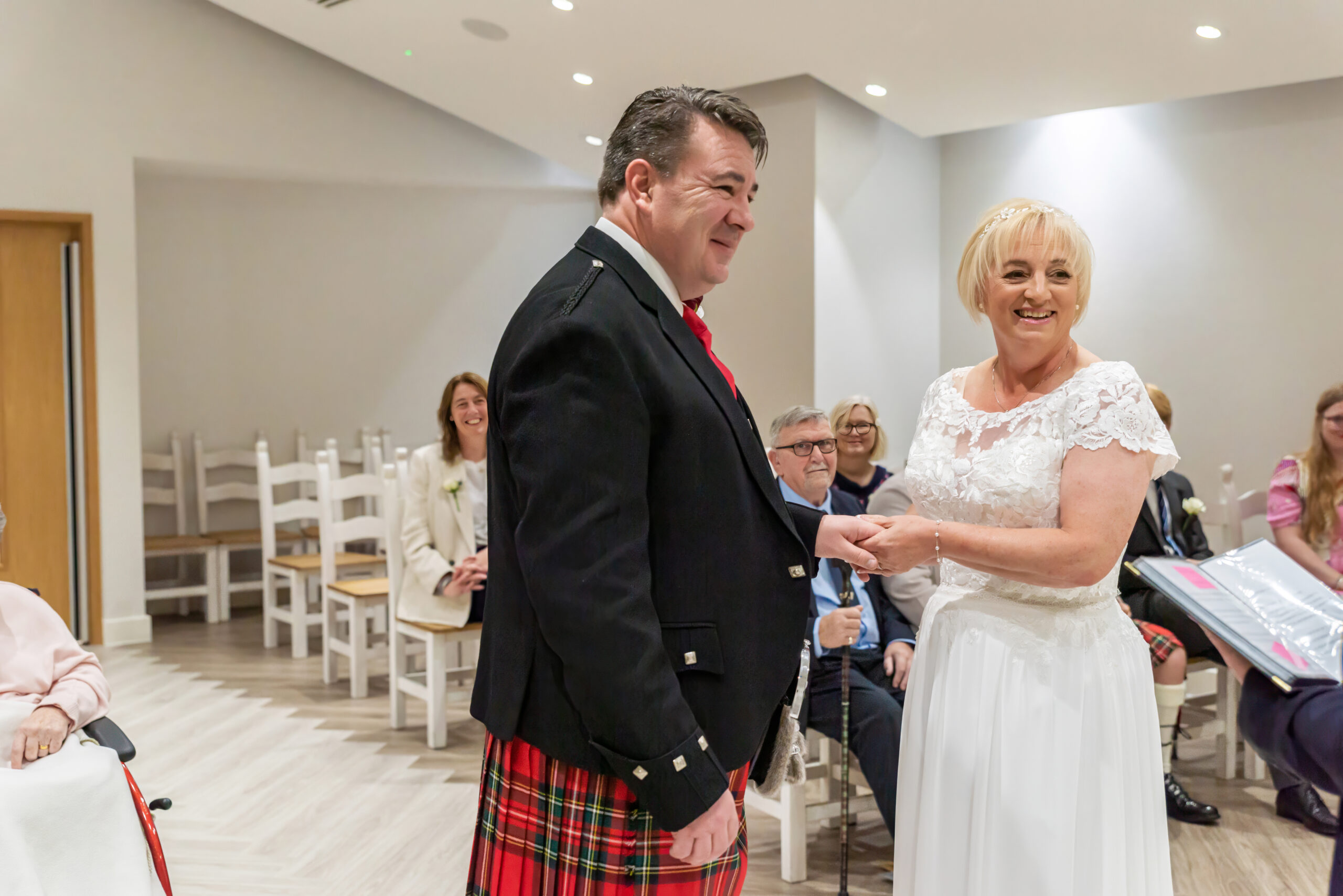 Photo of a bride and groom laughing during their wedding ceremony in Milton Keynes registry office
