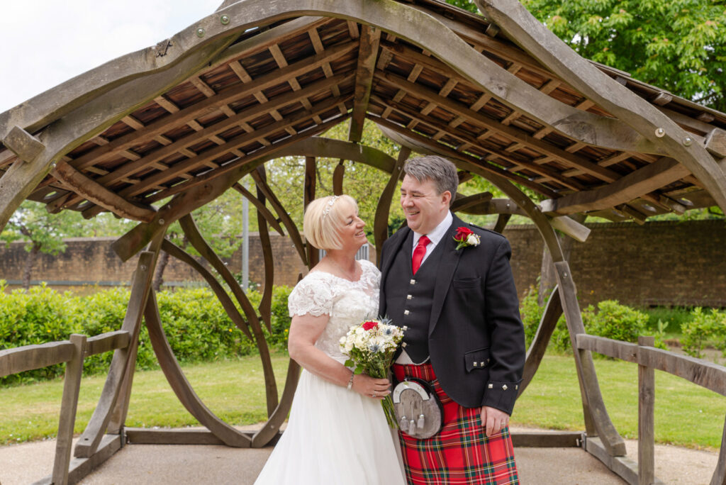 Photo of a bride and groom enjoying the gardens after their wedding at Bride and groom laughing during their wedding ceremony at Milton Keynes Registry Office