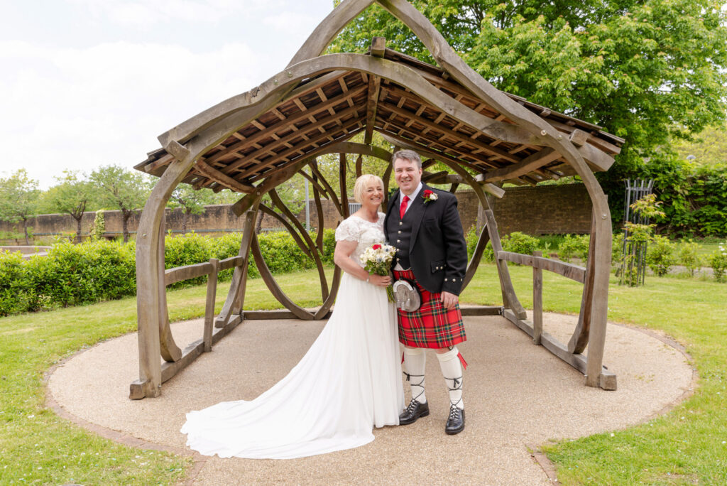 Photo of a bride and groom enjoying the gardens after their wedding at Bride and groom laughing during their wedding ceremony at Milton Keynes Registry Office