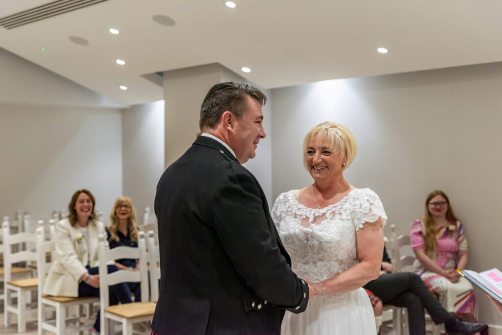 Bride and groom laughing during their wedding ceremony at Milton Keynes Registry Office