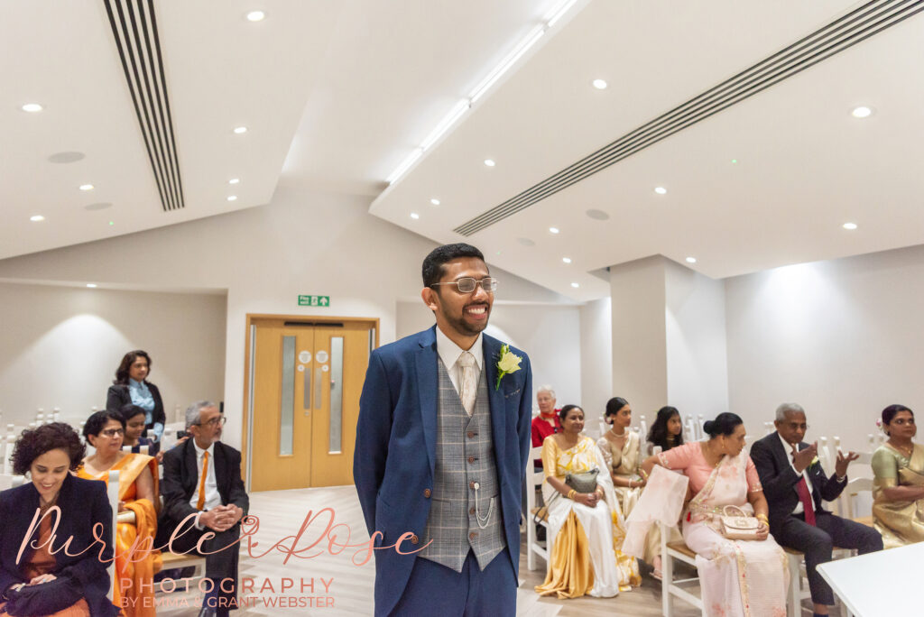 Groom smiling s he waits for his bride to arrive at Milton Keynes Registry Office