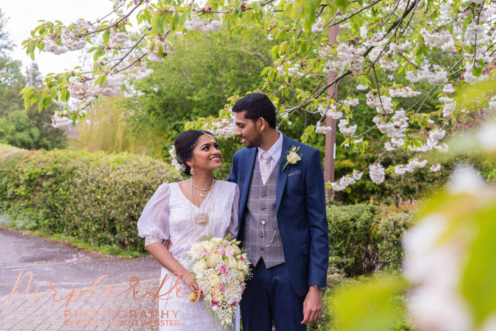 Bride and groom under spring blossom tree after their wedding at Milton Keynes Registry Office