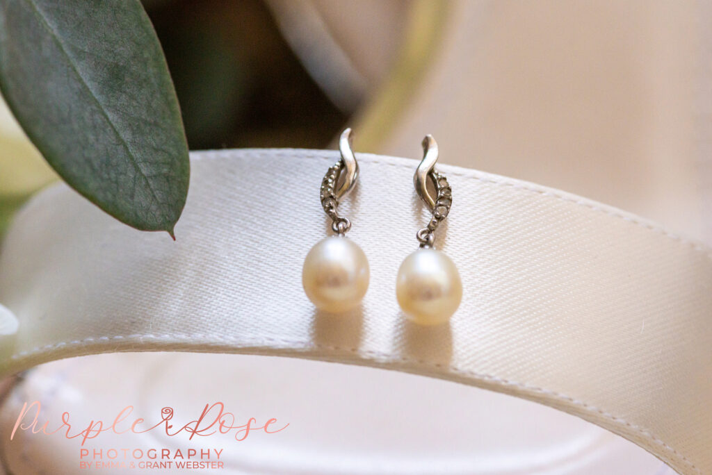 Close up of a brides pearl ear rings on her wedding day at Chicheley Hall in Milton Keynes