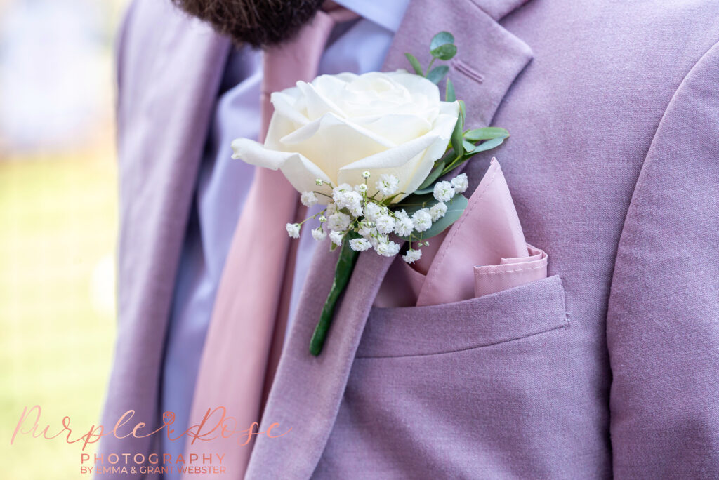 Close up photo of a grooms button on his wedding day in Milton Keynes