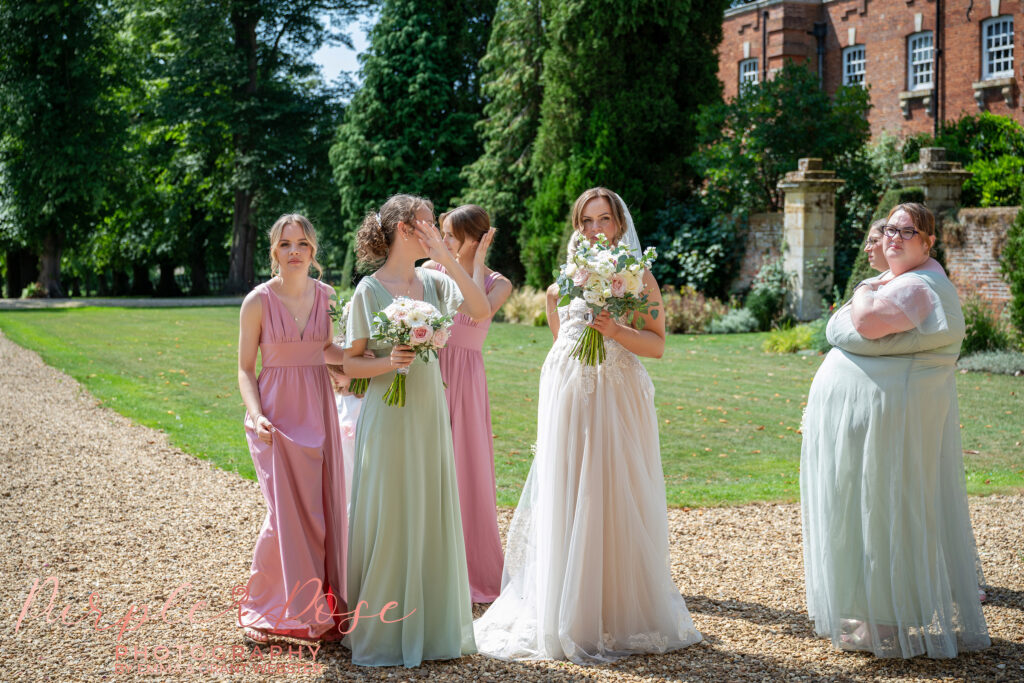 Bride talking to her bridesmaids on her wedding day at Chicheley Hall in Milton Keynes