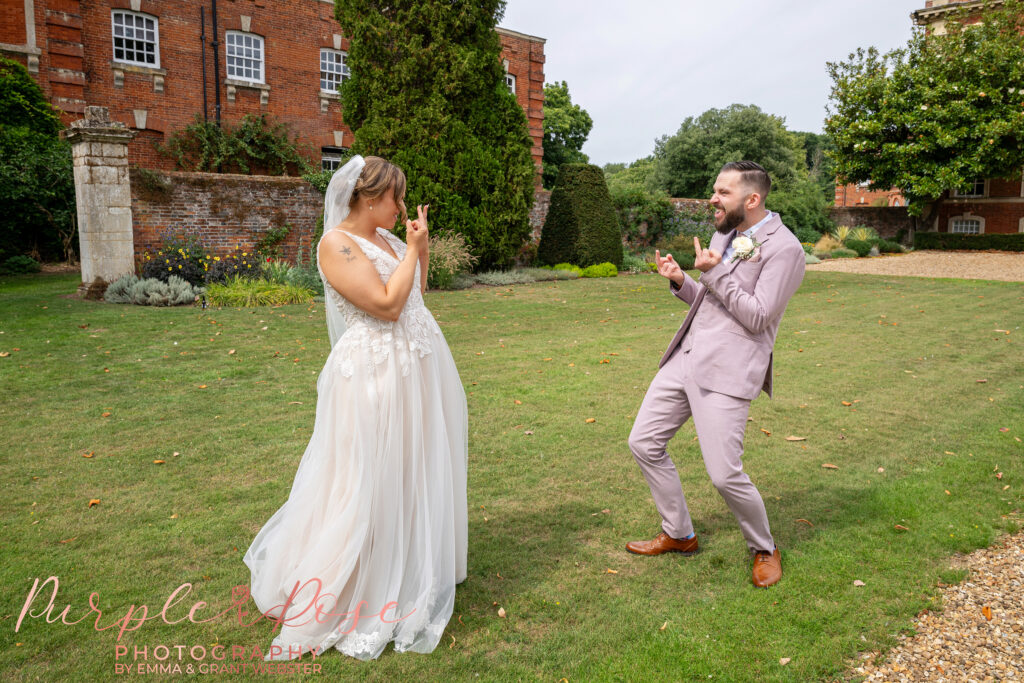 Bride and groom pulling faces at each other on their wedding day at Chicheley Hall in Milton Keynes