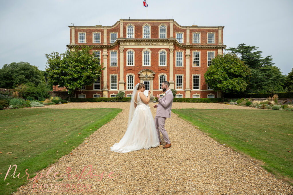 Bride and groom pulling faces at each other on their wedding day at Chicheley Hall in Milton Keynes
