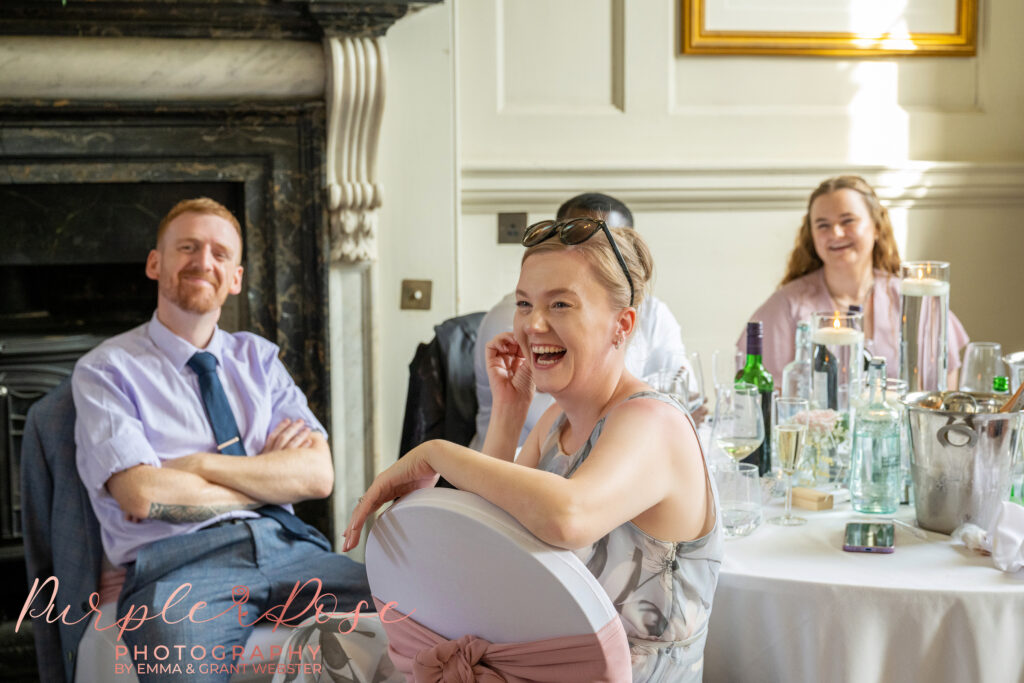 Wedding guest laughing during the speeches at a wedding at Chicheley Hall in Milton Keynes
