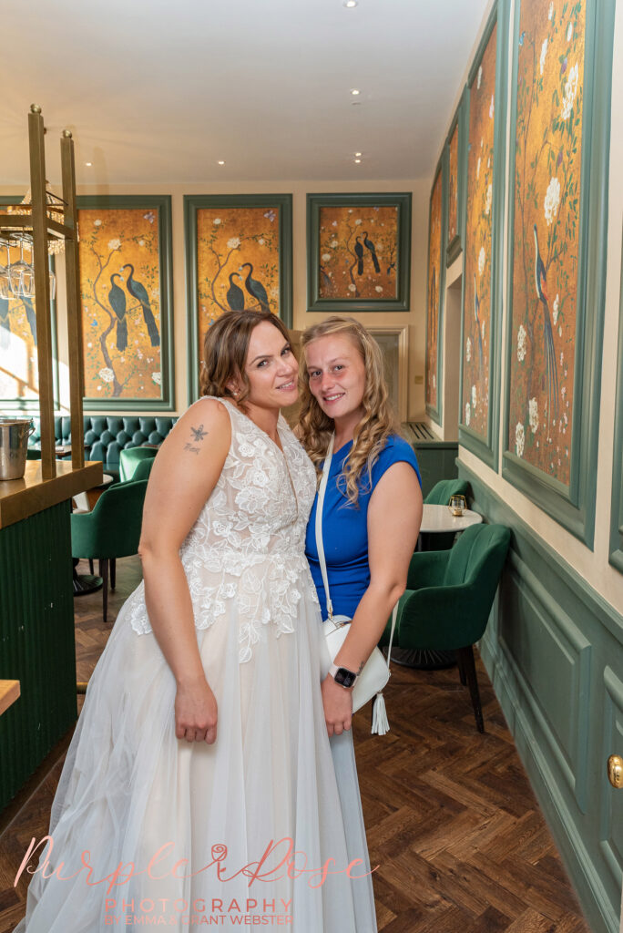 Bride posing for a quick photo with a wedding guests at her wedding at Chicheley Hall in Milton Keynes