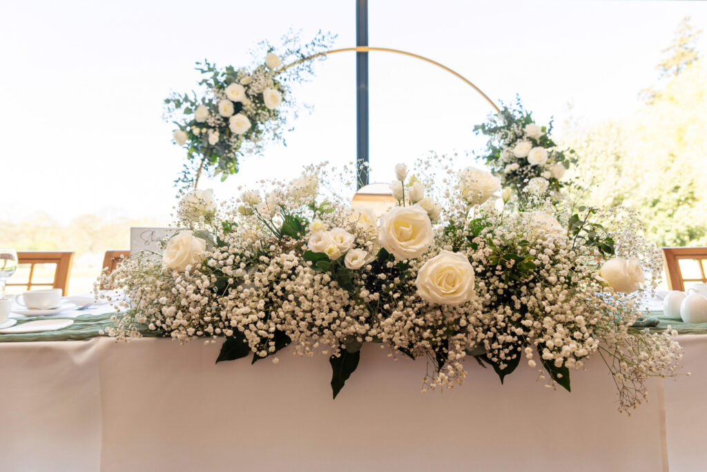 Photo of the flowers on the top table for a wedding at Dodford Manor in Northampton