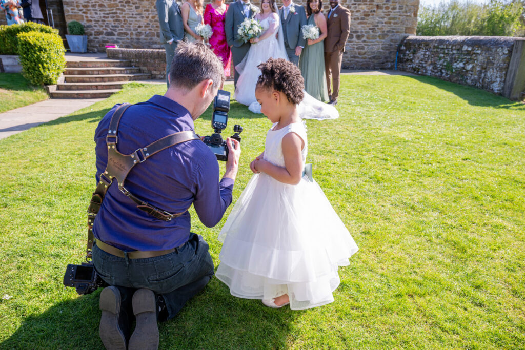 Wedding photographer showing a child how to use his camera at a wedding at Dodford Manor in Northampton