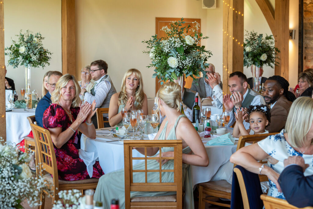 Wedding guests clapping during the speeches at Dodford Manor on a wedding day