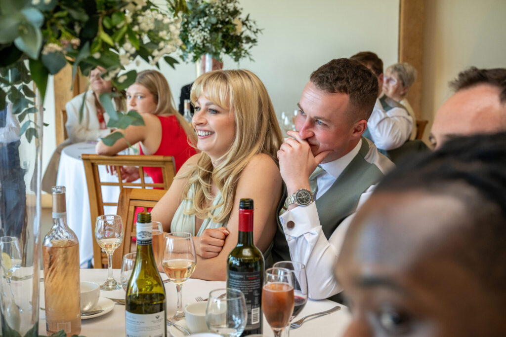 Wedding guests laughing at a wedding at Dodford Manor