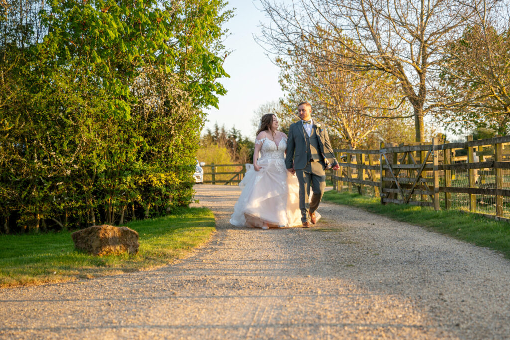Bride and groom walking through the grounds of Dodford Manor